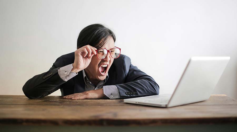 Personne frustrée devant son ordinateur à cause d'emails non reçus